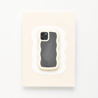A highly protective Coconut Lane Curvy Phone Case - Cream, featuring a wavy design, is placed centrally on a rectangular surface layered to resemble paper cut-outs in various shades of white. The screen of the iPhone 15 is off, reflecting light slightly.