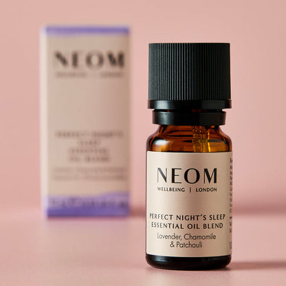 NEOM Perfect Night’s Sleep essential oil blend bottle with its box softly blurred behind it.