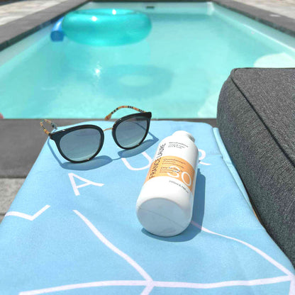 France Laure Day-to-Day SPF 30 sunscreen bottle and sunglasses on poolside towel, ideal for face & body sun protection