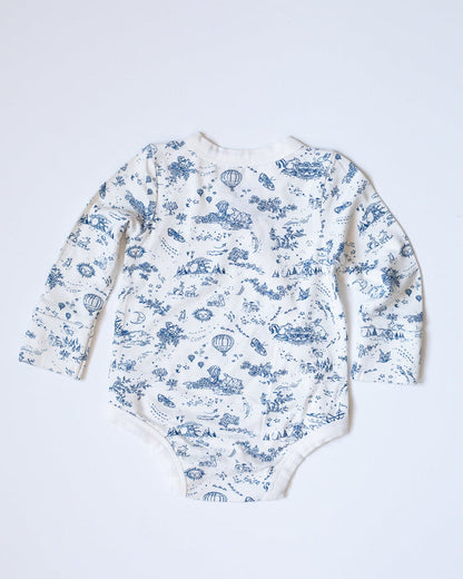 Blue-and-white toile bodysuit with flowers, bunnies, butterflies, hot air balloons, boats, moons, and suns.